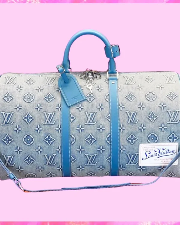 Louis Vuitton denim weekend bag with monogram pattern, blue leather handles, and adjustable shoulder strap.